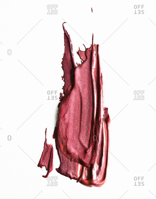Pink cosmetics smeared on white background