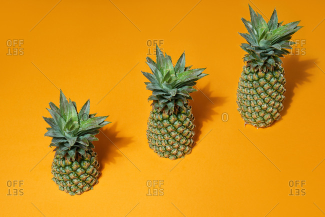 Fresh juicy pineapple stairs on yellow background. Development Concept.
