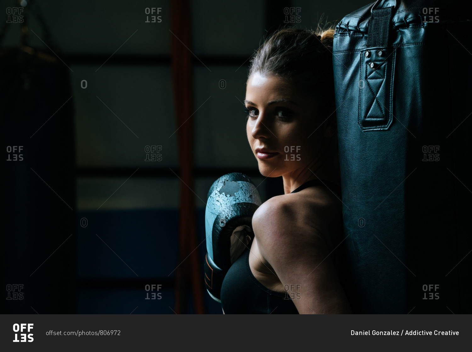 Sportswoman in boxing gloves in gym
