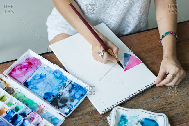 Latin artist painting with watercolor in her studio