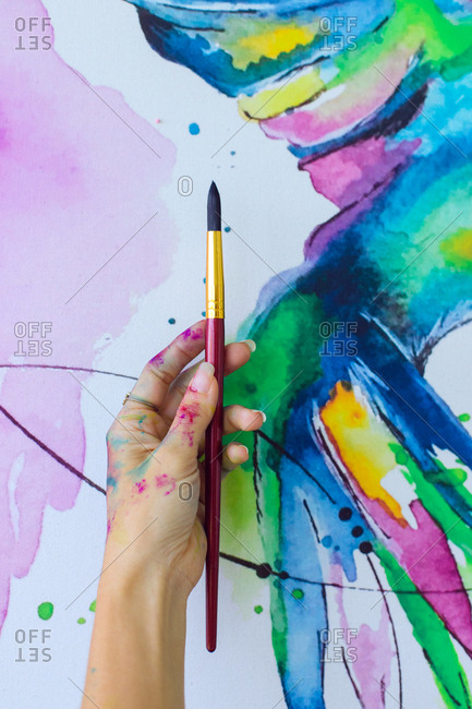 Latin artist painting with watercolor in her studio