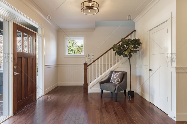 Armchair and tree in house entryway, Lake Oswego, Oregon, USA