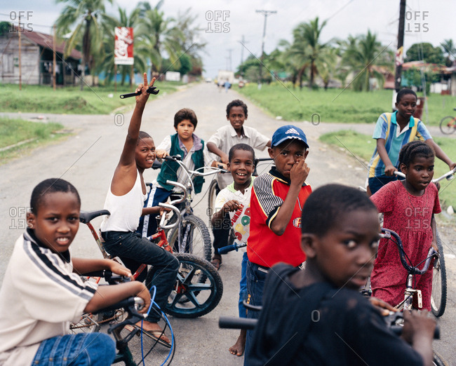 PANAMA, Bocas del Toro, - March 22, 2017:  kids on bikes hang in the street and wait to get access to the airport runway, Central America