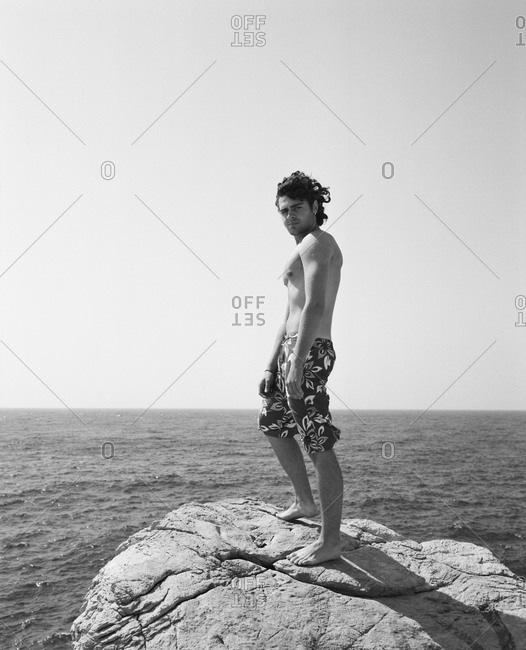 CROATIA, Dubrovnik, Dalmatian Coast, - September 28, 2010:  portrait of young man at Buza Bar, standing on rock before jumping into the ocean. The bar is located on the side of the cliff in Dubrovnik.