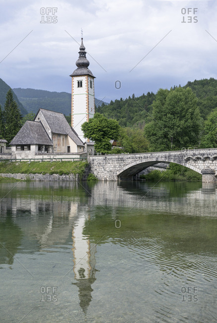 Tower, bridge and building reflected in still lake,Bohinj, Upper Carniola, Slovenia