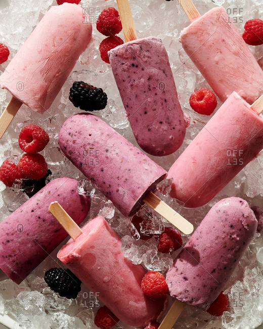 Raspberry and blackberry popsicles on ice