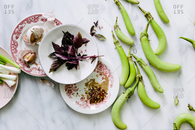 Green eggplant, seeds, amaranth, and garlic on marble surface