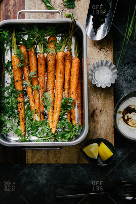 Roasted carrots in a pan beside fresh coffee