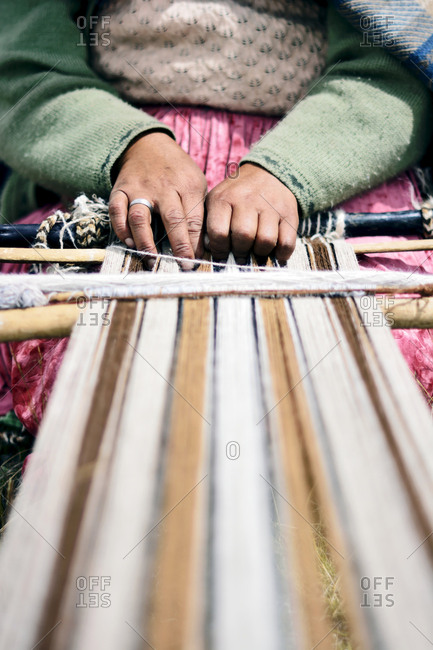 Hands of an Aymara artisan woman weaving with wool