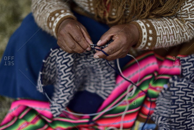 Quechua woman knitting an alpaca coat