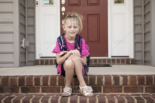 Cute Blonde Curly Headed Girl Waits For School Bus On Front Steps