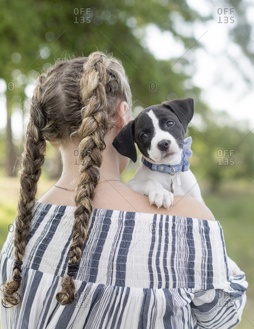 girl with holding dog over her shoulder