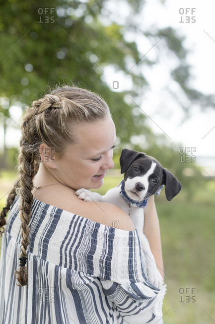 Girl with pick tails smiling at a dog with floppy ears