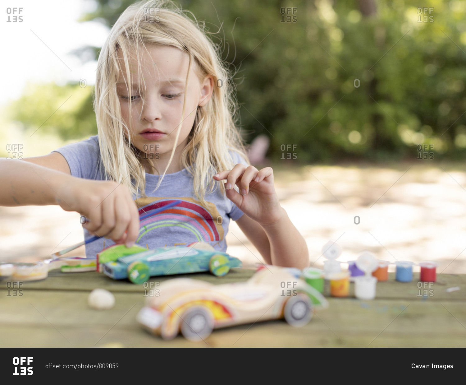 Girl painting a race car  with messy hair
