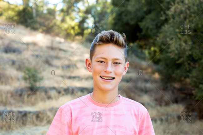 Portrait of a teenage boy with braces outside