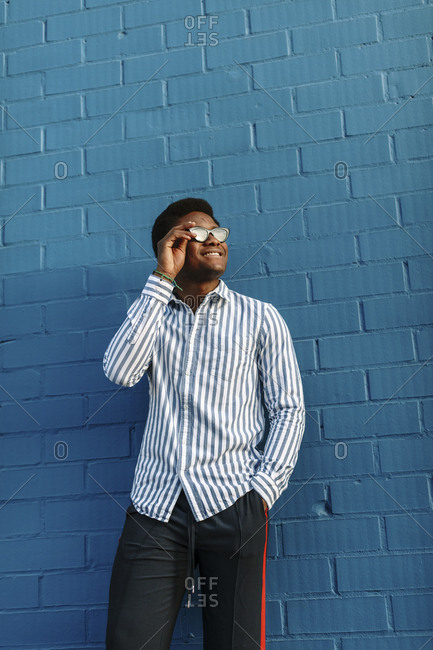 Low angle portrait of a stylish black man wearing blue striped collared shirt