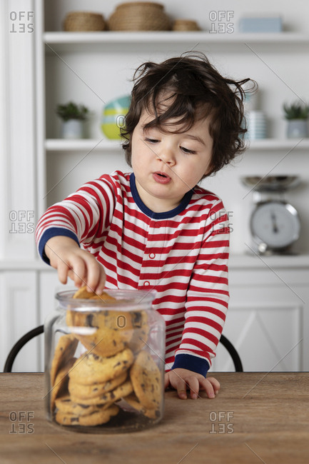 Cute young child reaching into a cookie jar