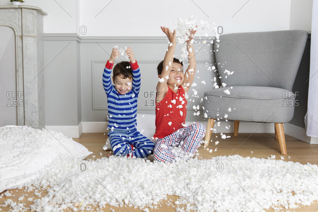 Young boys making mess with pillow stuffing
