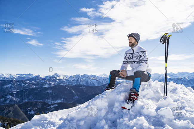 Germany- Bavaria- Brauneck- man in winter sitting on mountaintop
