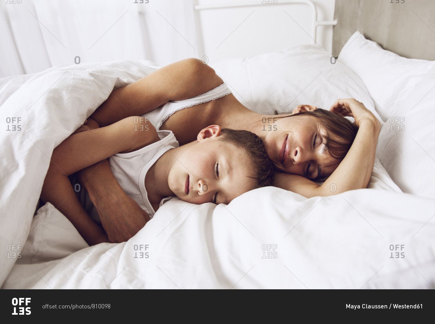 Mom And Son Share Bed Mother and son cuddling in bed stock photo - OFFSET