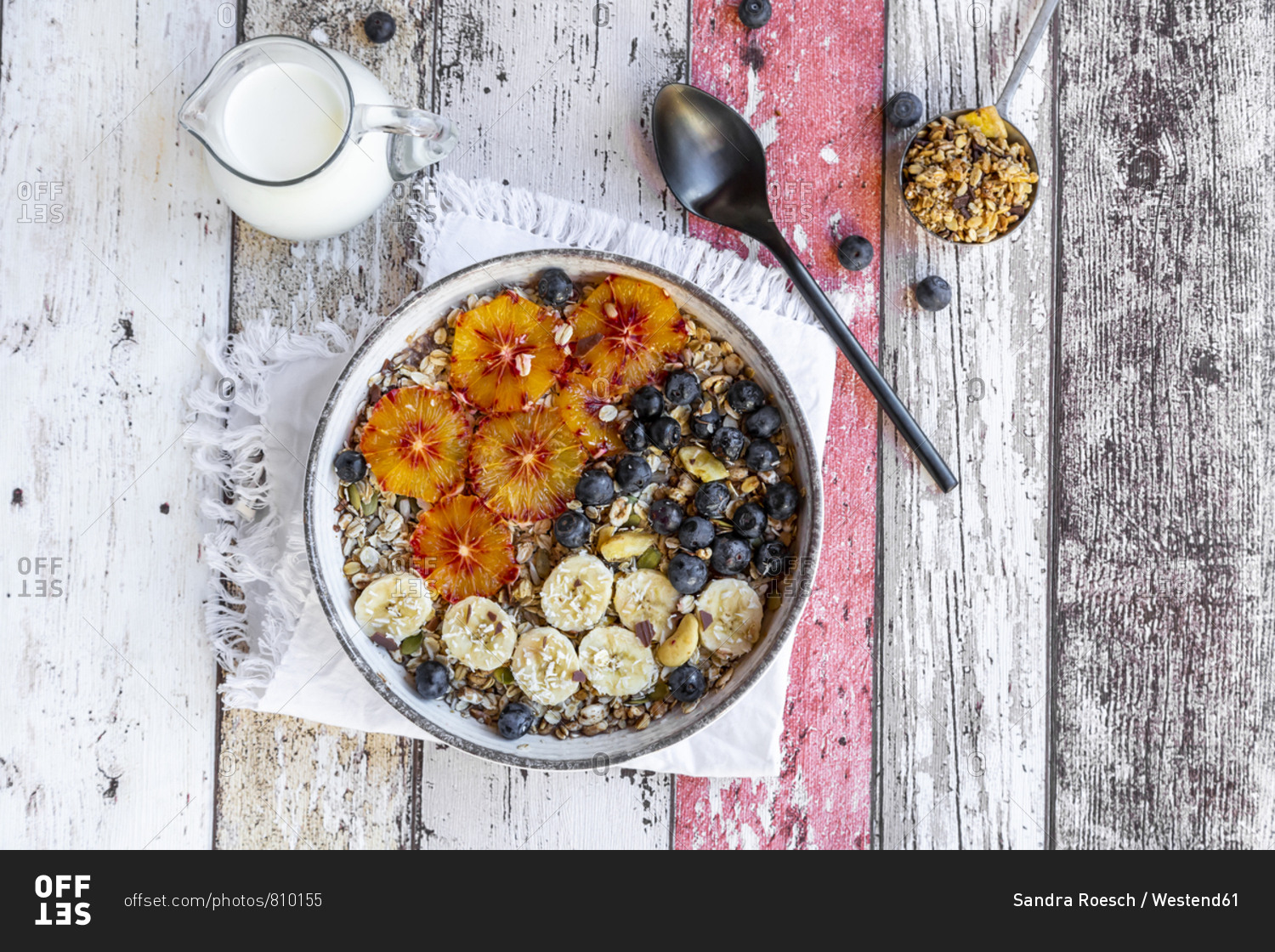 Cereals with banana- blueberries- blood orange- coconut flakes and milk