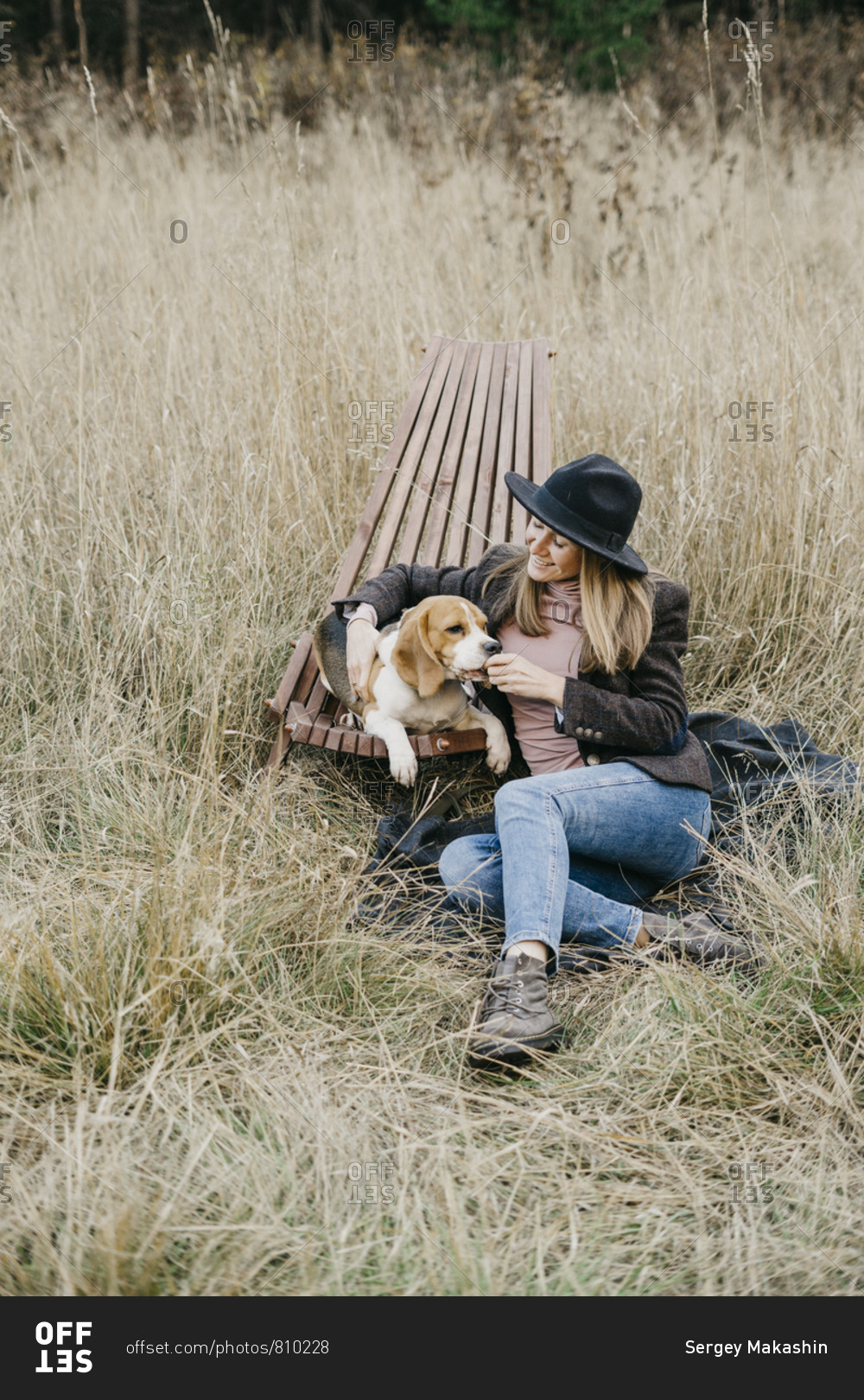 Young beautiful woman playing with Beagle dog walking in nature in the Park.
