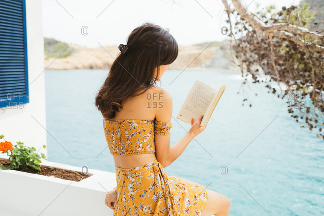 Young woman enjoying a book with sea views