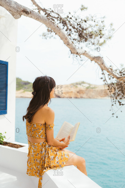 Young woman enjoying a book with sea views