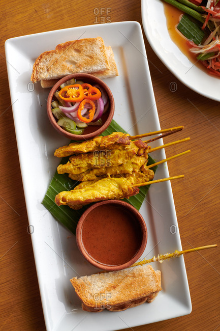 Chicken satay skewers with toast and pickled veggies with a sweet peanut sauce