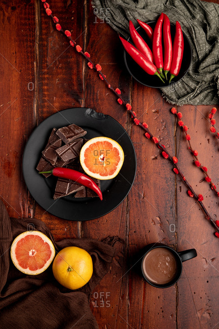 Mug of tasty hot chocolate placed on timber tabletop near assorted desserts and fruits for breakfast