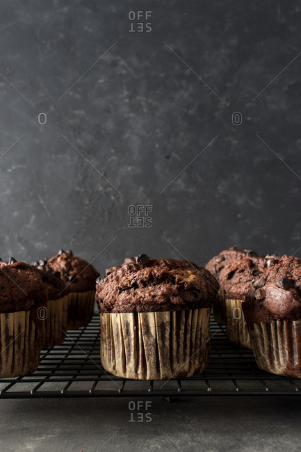 Yummy muffin made with chocolate and banana placed on blue towel near gray wall