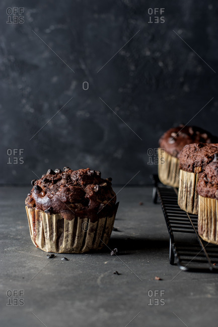Yummy muffin made with chocolate and banana placed on blue towel near gray wall