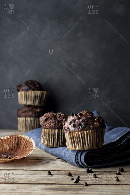 Yummy muffin made with chocolate and banana placed on blue towel near gray wall