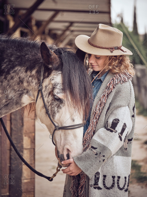 Cheerful cowgirl interacting with horse