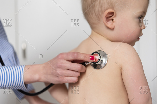 Pediatrician using stethoscope on girl