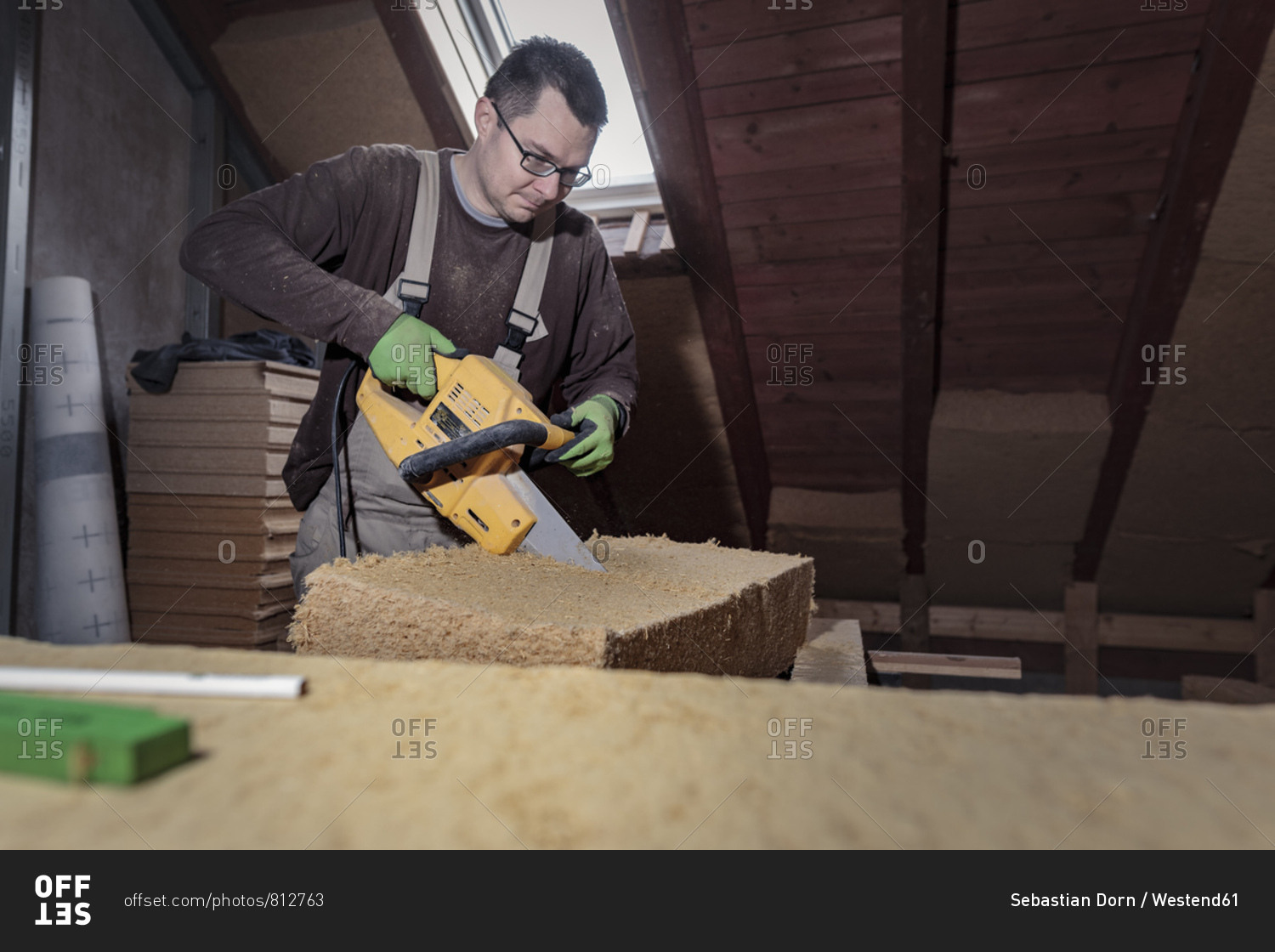 Roof insulation- worker placing wood fiber insulation at the roof