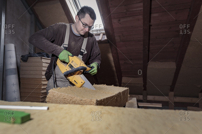 Roof insulation- worker placing wood fiber insulation at the roof