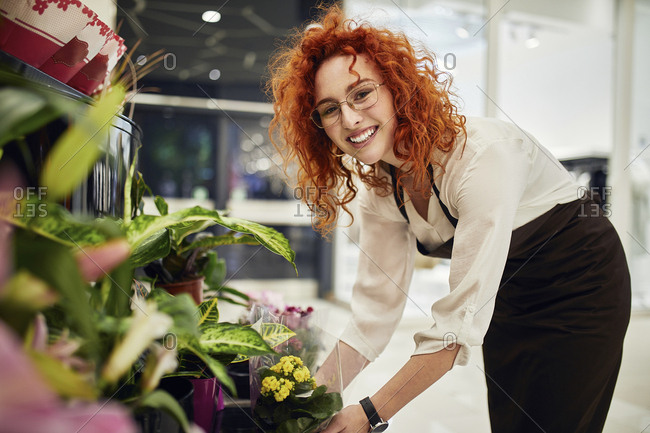 Portrait of smiling florist arranging flowers in flower shop