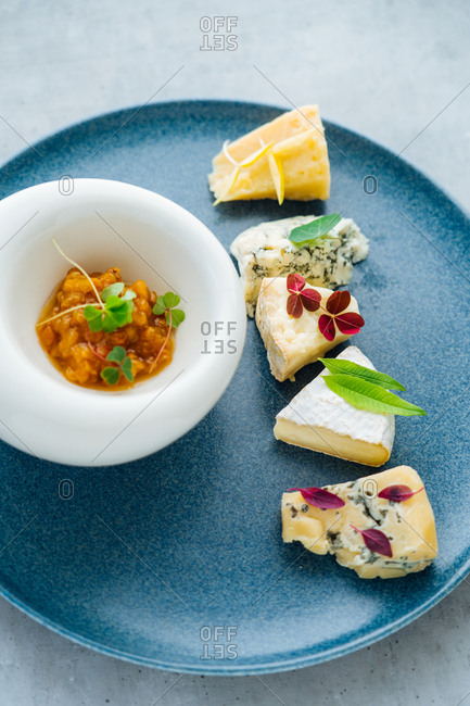 Overhead view of a cheese appetizer on blue plate