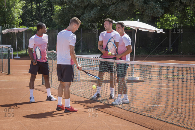 Group of young men playing tennis on a sunny day, Bavaria, Germany