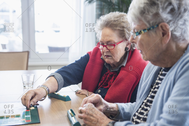 Senior women playing board game in rest home
