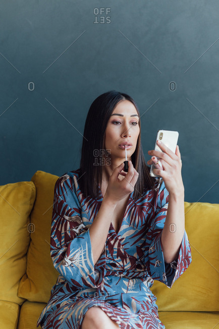 Beautiful brunette puts on lip gloss