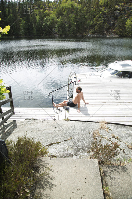 Man relaxing on jetty - Offset