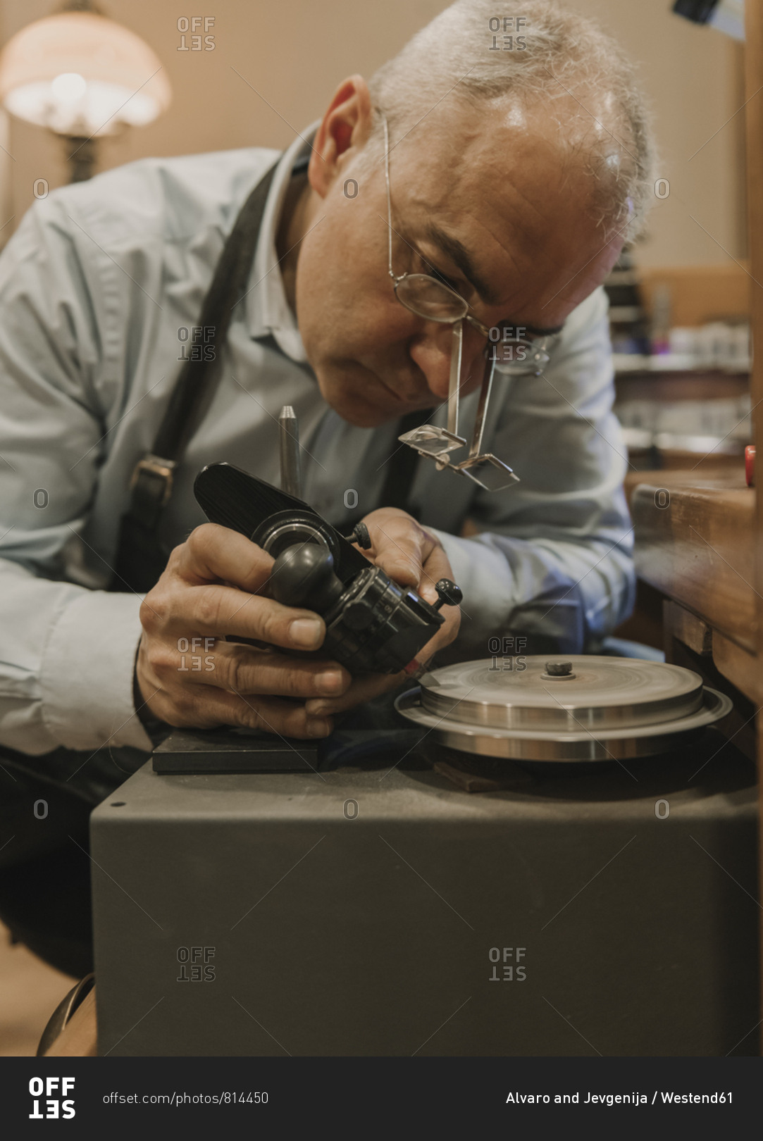 Artisan making jewelry in his workshop stock photo - OFFSET