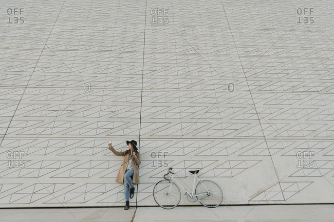 Young hipster woman near to a bicycle making a selfie