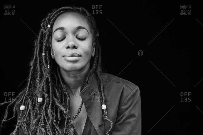 Portrait Of Woman With Dreadlocks In Front Of Black