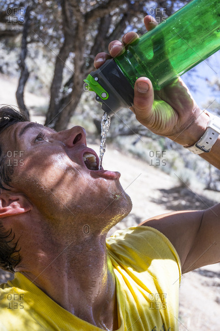 A man hydrating while hiking to Lone Peak,  Utah