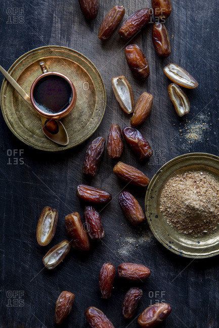Dry dates, date sugar and date syrup over black wooden background