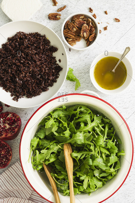 Ingredients in bowls for a rocket, pomegranate and rice salad.