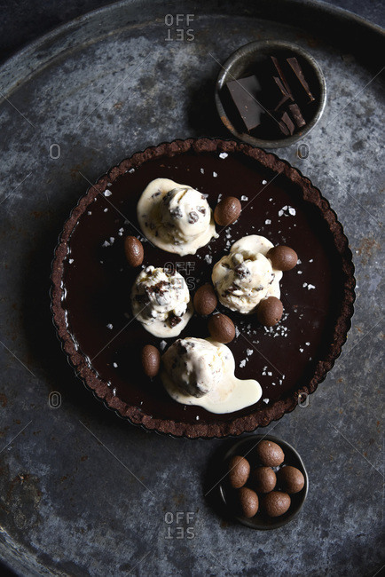 Chocolate tart with melting ice cream on a dark background